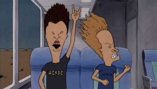 Beavis and Butthead sitting on a bus and headbanging to music. They have on t-shirts that promote AC/DC and Metallica.